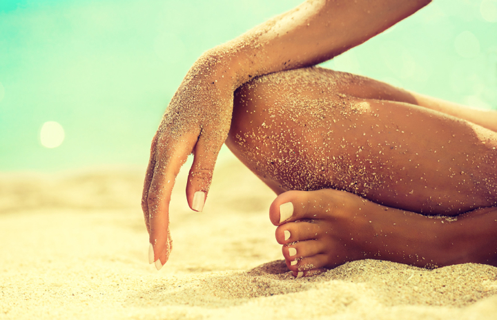 A woman enjoying the beach with her arms raised