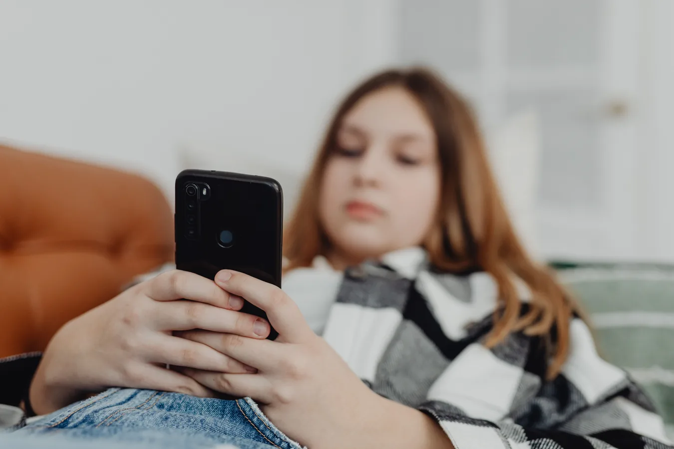 A young person using a smartphone at home