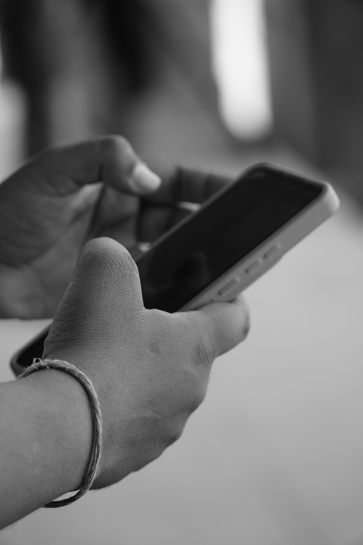 Hands holding a phone in a black-and-white photograph