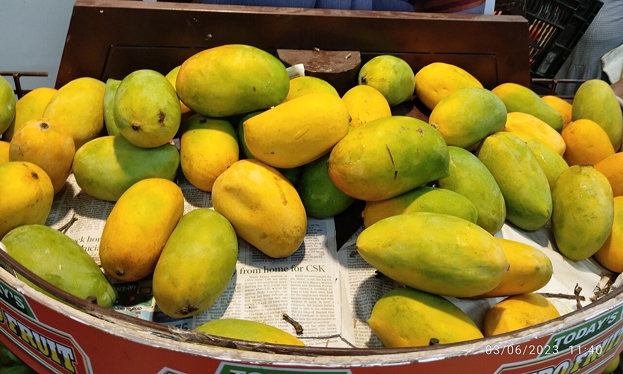 A market display of green and golden Kesar mangoes