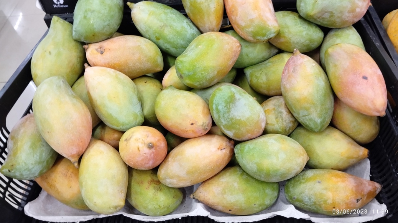 A market crate filled with long green and yellow Totapuri mangoes