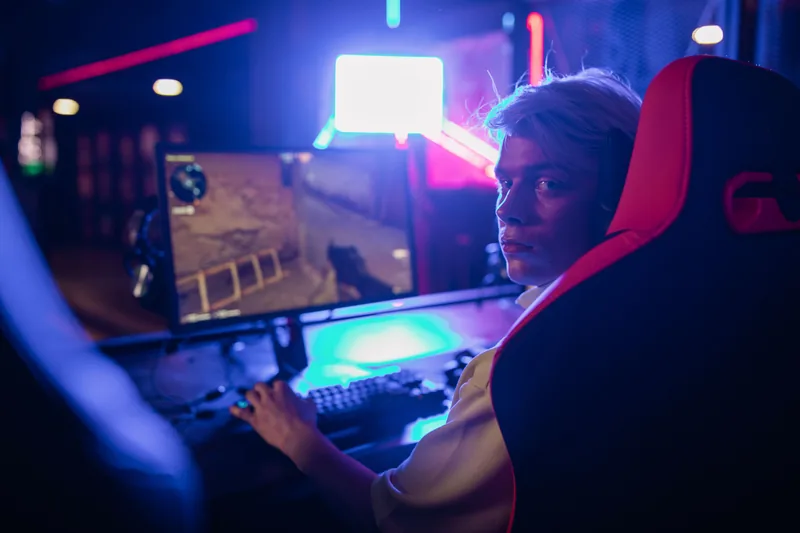 A teenage gamer surrounded by glowing screens