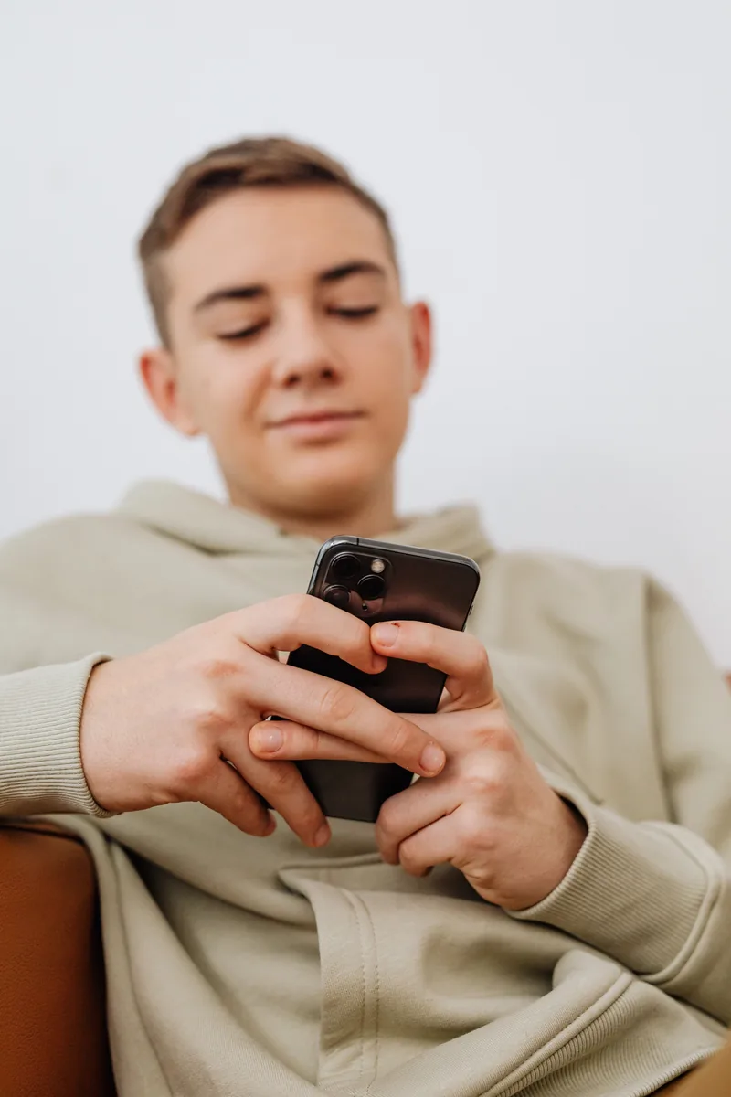 A teenage boy using a smartphone