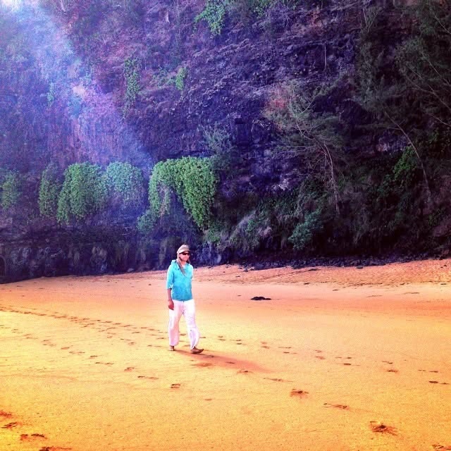 Michael Mackintosh standing on a beach beneath green cliffs
