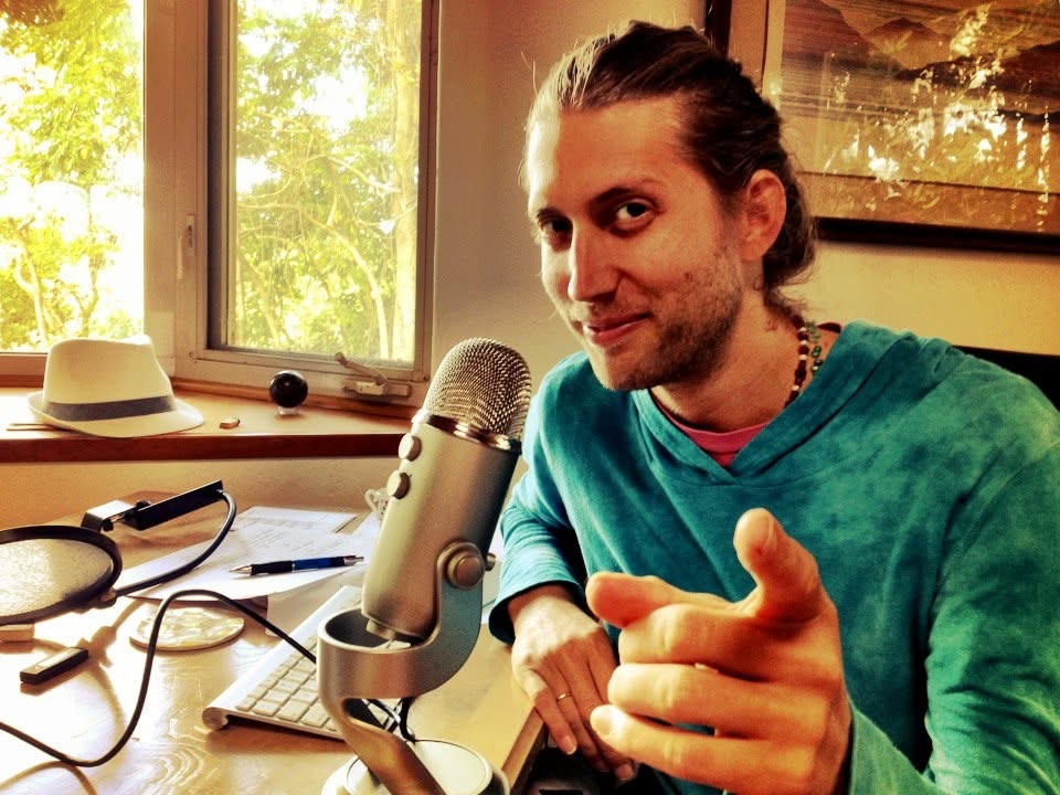 Michael Mackintosh sitting beside a microphone and computer