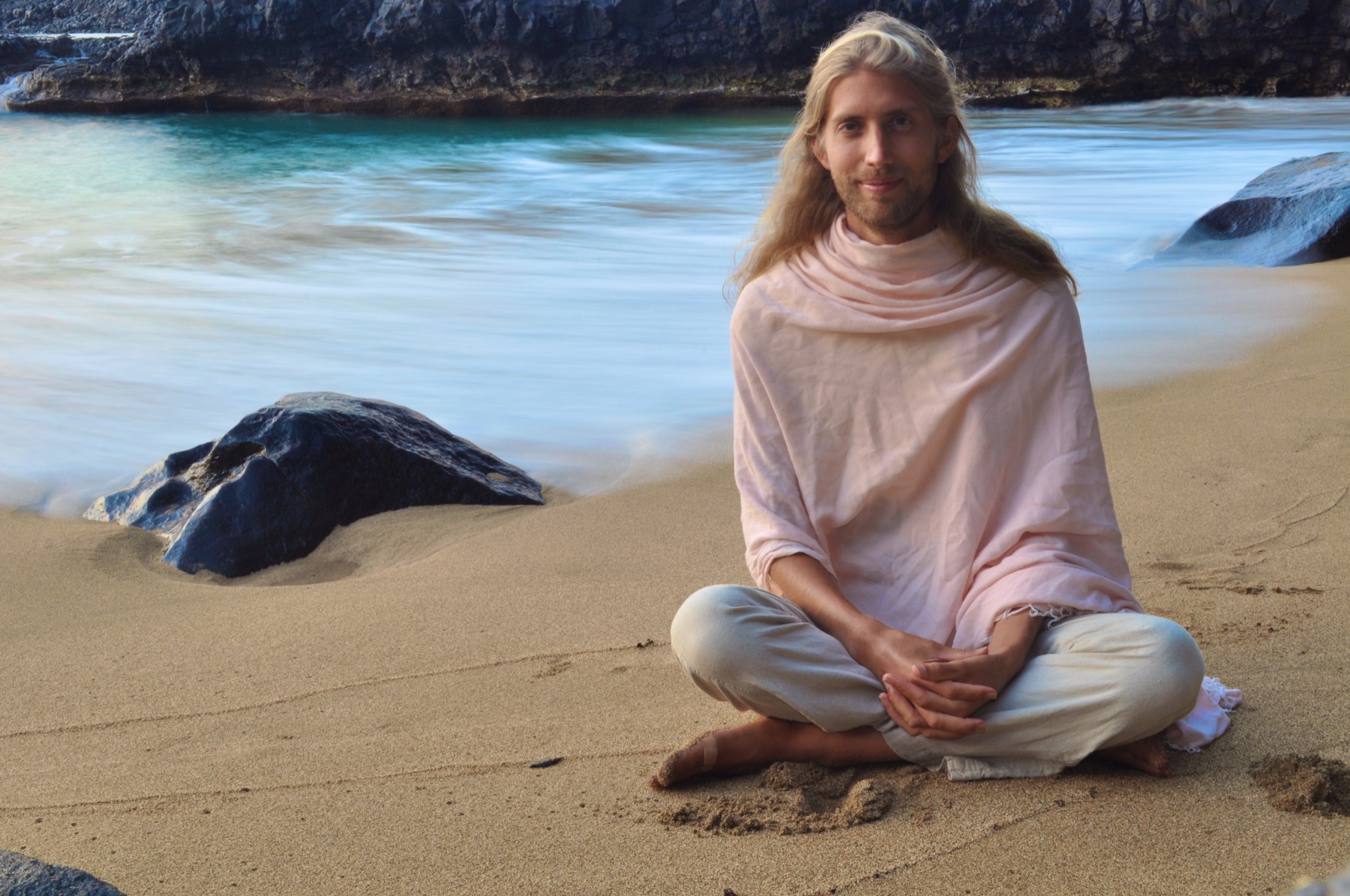 Michael Mackintosh sitting quietly on a beach