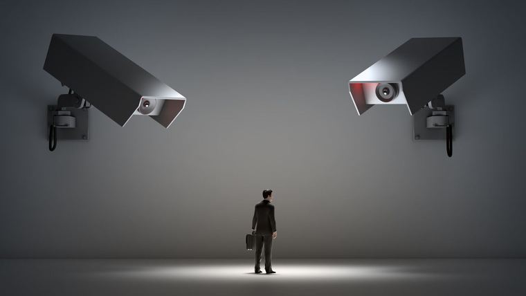 A person alone beneath security cameras
