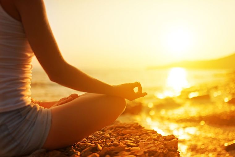 A person sitting quietly at sunrise